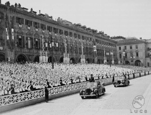 L'Alfa Romeo, con a bordo Mussolini, attraversa piazza San Carlo gremita di piccole italiane